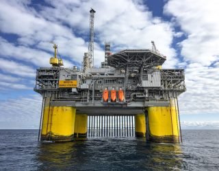 Majestic offshore oil platform in Norway's North Sea, under blue skies.